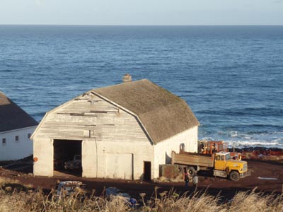 Photo of the machine shop, a white barn-shaped building.